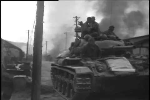 Sherman tank drives through burnt village - 1950 Stock Footage 92761053