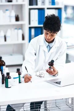 Shes been working hard to develop new treatments. a young scientist writing Stock Photos