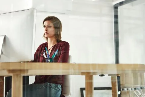 Shes focused on the immediate task. a young female designer working at her desk Stock Photos