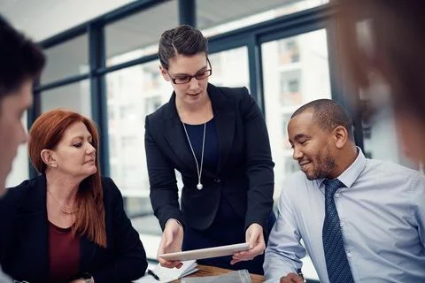 Shes got a proposal to put forth. a group of businesspeople using a digital Stock Photos