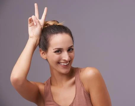Shes got subtle con. An attractive young woman against a purple background. Stock Photos