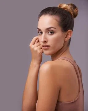 Shes got subtle con. An attractive young woman against a purple background. Stock Photos