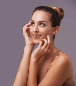 Shes got subtle con. An attractive young woman against a purple background. Stock Photos