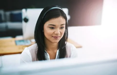 Shes hard at work solving your problems. an attractive young female operator Stock Photos