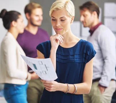 Shes impressed with the planning process. a young female designer looking over Stock Photos