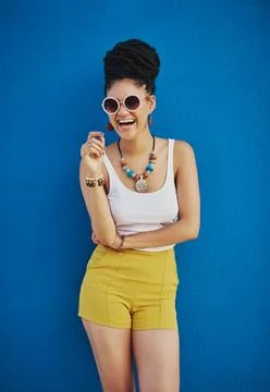 Shes positively groovy. an attractive young woman wearing funky sunglasses Stock Photos