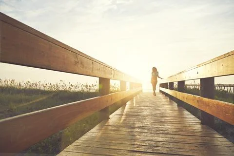Shes ready to soak up some rays. a young woman in a bikini on a walkway near the Stock Photos