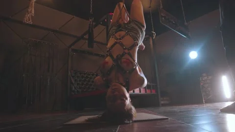 Shibari c BDSM concept - a man hangs woman on ropes head down Stock Footage 142675793