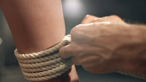 Shibari master tying rope around slim girl ankle Stock Footage 87562882