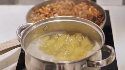 Shifting Focus Between Boiling Potatoes and Sautéed Chanterelle Sauce with Ham Stock Footage 295248285