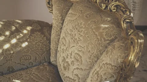 Shifting patterns of light dancing across an ornate antique couch Stock Footage 295183717