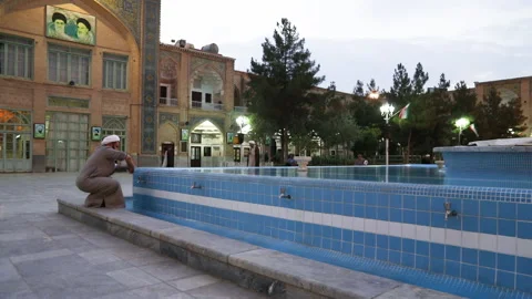 A shiite cleric performs ablution in the courtyard of Qom Seminary Stock Footage 149085871