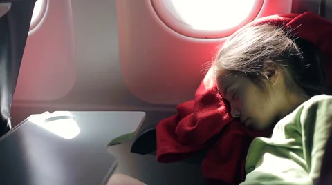 Сhild sleeps in an airplane in flight Stock Footage 51008395