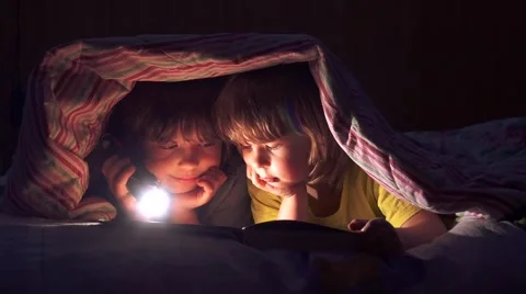 Сhildren read a book under the covers Stock-Footage 59901580