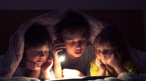 Сhildren read a book under the covers Stock Footage 59933023