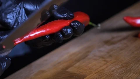 Сhili pepper is cut with a knife. Cutting red hot pepper on cutting board Stock Footage 86532750