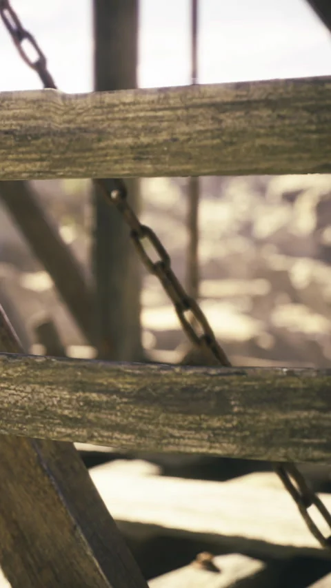 Shimmering light dances through rustic wooden beams and lingering chains Stock Footage 331803535