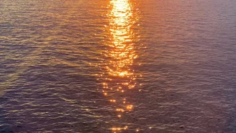 The shimmering rays of the setting sun reflect off the surface of the water Stock Footage 327380971