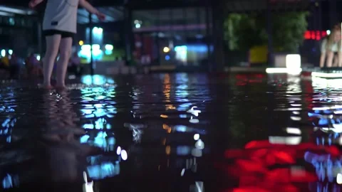 The shimmering reflections of red lanterns dance on the water as children play Stock Footage 240580101