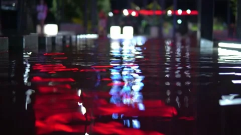 The shimmering reflections of red lanterns dance on the water as children play Stock Footage 240580467