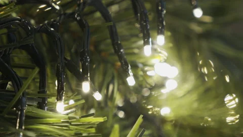 Shine of blinking lights over the artificial spruce branches 4K video Stock Footage 145818620