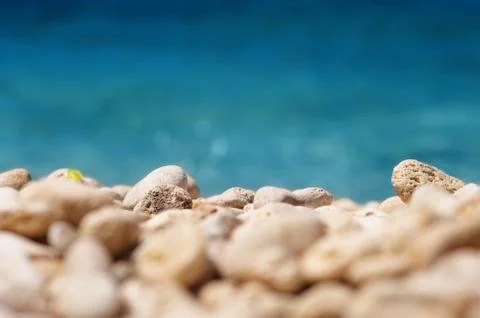 Shingle beach with blured sea at the sunset Stock Photos