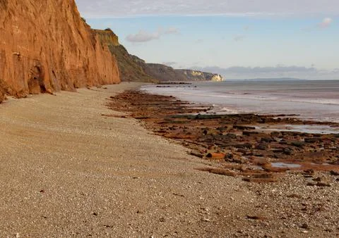 The shingle beach at Sidmouth in Devon with the red sandstone cliffs of the J Stock-Fotos