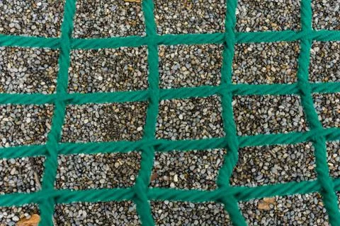 Shingle seen through dark green net Stock Photos