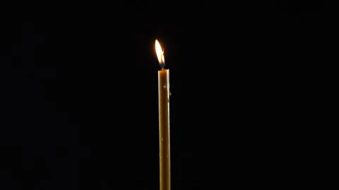 Shining candle flame in a dark room. Fire on a black background. Stock-Footage 169995324