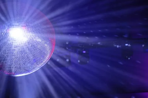 Shining disco ball reflecting light rays in a dark party atmosphere Stock Photos