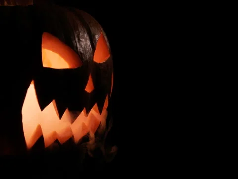 Shining Jack-O-Lantern. Halloween pumpkin with scary face isolated on the black Stock Footage 80141409