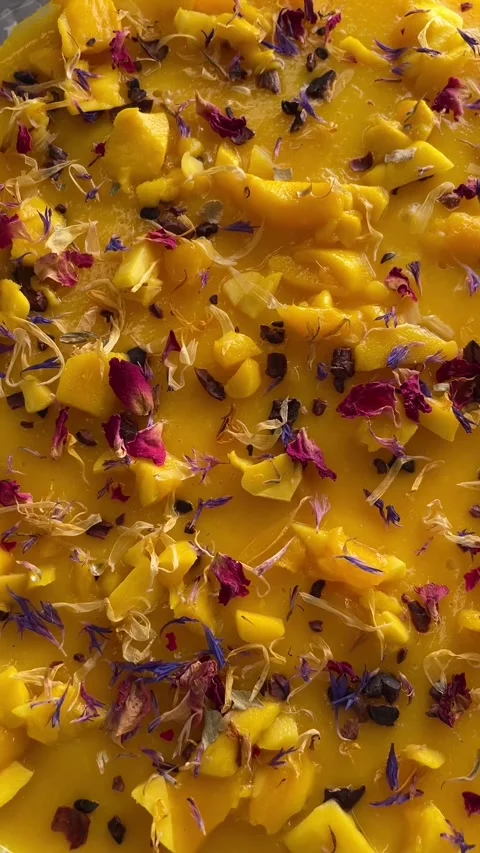 Shining mango delicacy decorated with withered roses and azure blooms Stock Footage 335366195