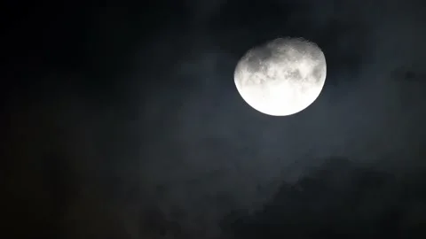 The shining Moon on the black sky during the night with the clouds passing over  Stock Footage 150932456