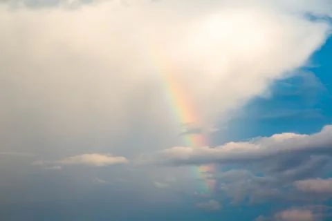 Shining rainbow through the clouds and the blue sky Stockfoto's