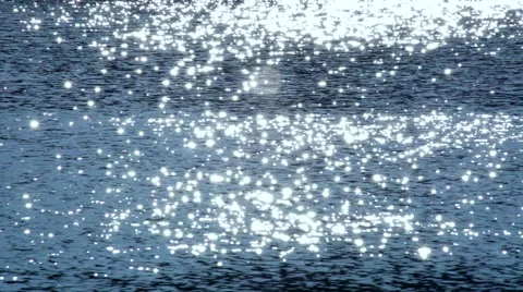 Shining sparkles on blue wavy water background. Vidéo 47012092