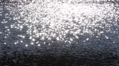 Shining sparkles on dark blue wavy water background. 库存影片 47012027