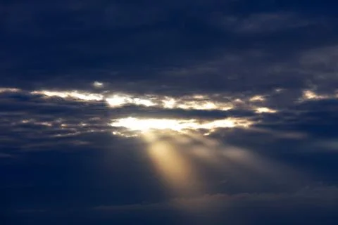 Shining sun behind dark clouds Stock Photos