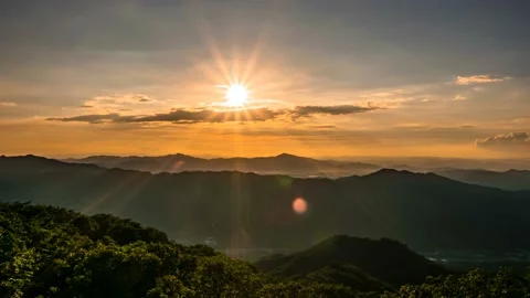 The shining sun disappears down the mountain ridge. Time lapse. 스톡 동영상 145742673