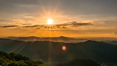 The shining sun disappears down the mountain ridge. Time lapse. Zoom in 스톡 동영상 145742677