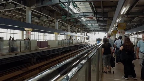 Shinkansen Bullet Train Approaching Busy Japanese Railway Platform with Waiting Stock Footage 342760718