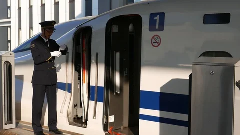Shinkansen driver points and calls out the time and station name. Stock Footage 98903918