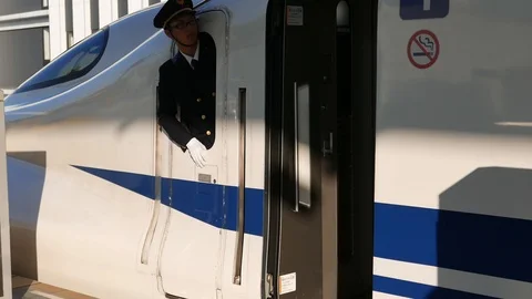 Shinkansen driver points and calls out the time and station name. Stock Footage 98904035