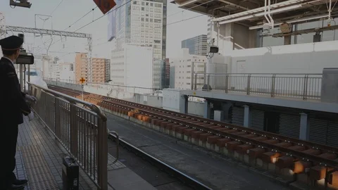 Shinkansen driver points and calls out the time and station name. Stock Footage 98904126
