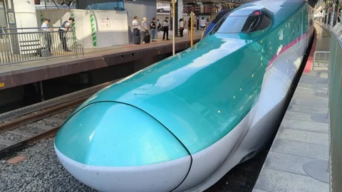 Shinkansen train pulling in next to another train Stock Footage 247500646