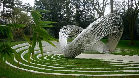 Shiny abstract infinity sign formed metall installation in the park Stock Footage 105293225