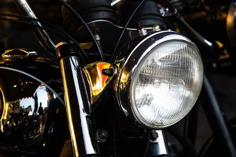 Shiny chrome round headlight and fuel tank reflection on a black classic mo.. Foto stock