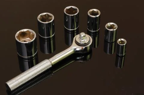 Shiny chrome six piece socket set on black surface Stock Photos