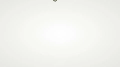 Shiny coins fall on a white table and fly apart in different directions. Stock Footage 129809129