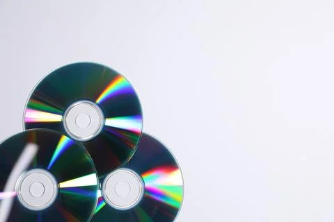 Shiny compact discs on light background, top view. Space for text Stock Photos