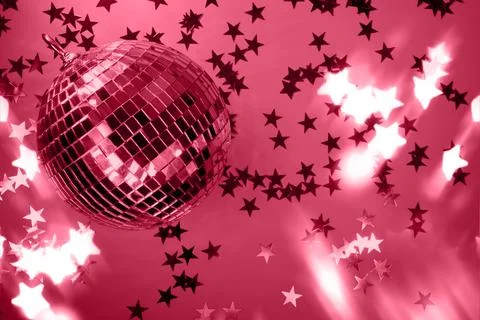 Shiny disco ball with rays on viva magenta background. Trending color of 2023 Stock Photos